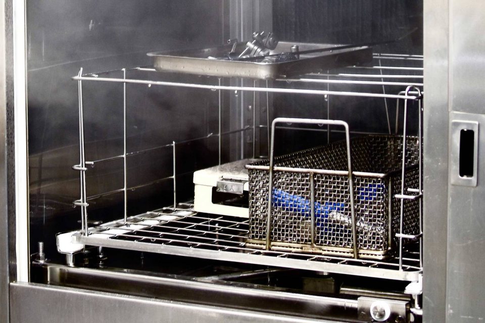 Metal trays full of instruments undergoing reusable life cycle testing by BoneSim.