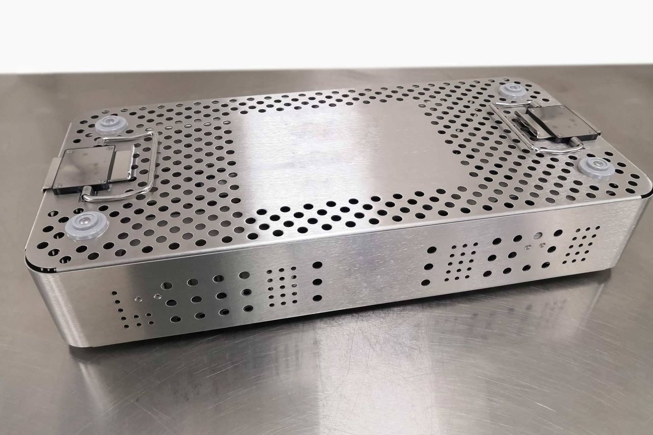 Metal case with holes in it as part of BoneSim's process of reprocessing reusable medical devices